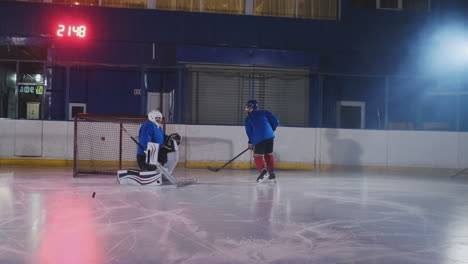 Ein-Hockeyspieler-Führt-Einen-Angriff-Auf-Das-Gegnerische-Tor-Durch.-Der-Im-Helm-Liegende-Spieler-Fängt-Den-Puck-Und-Rettet-Das-Spiel.-Eishockeyspieler,-Mann-Des-Spiels